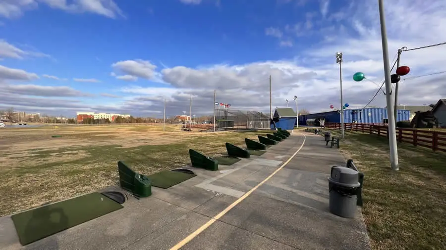 Wide view of driving range tee line with driving range field in background